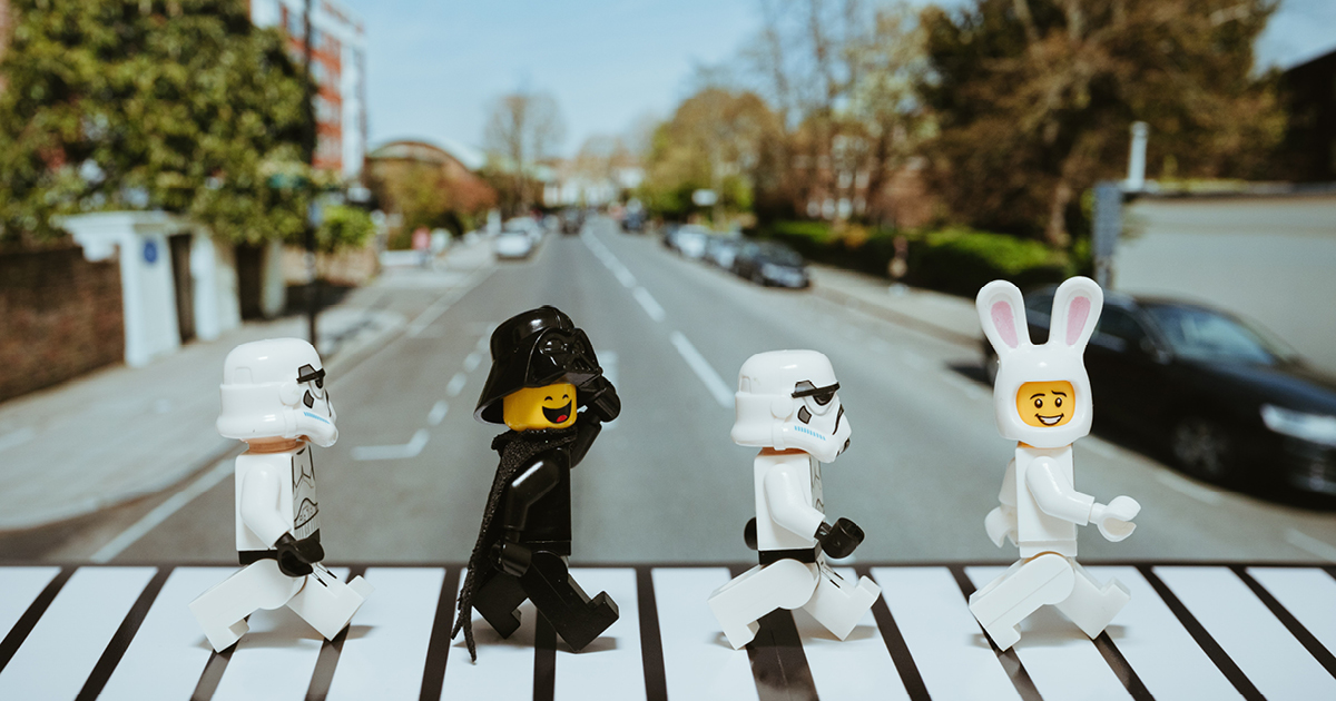 lego figures crossing a road on a level crossing.