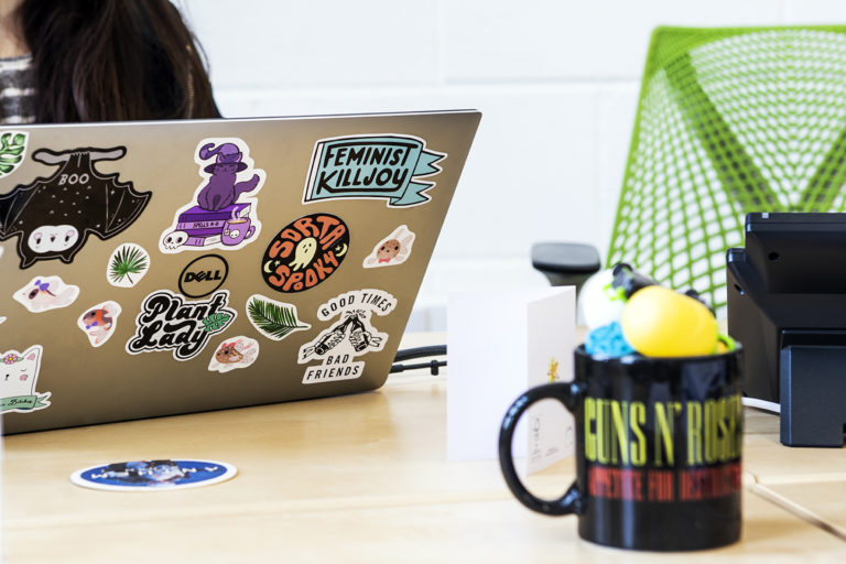 This is Katie's laptop. It's covered in stickers because she's cool. We're not sure who the Guns and Roses mug belongs to.